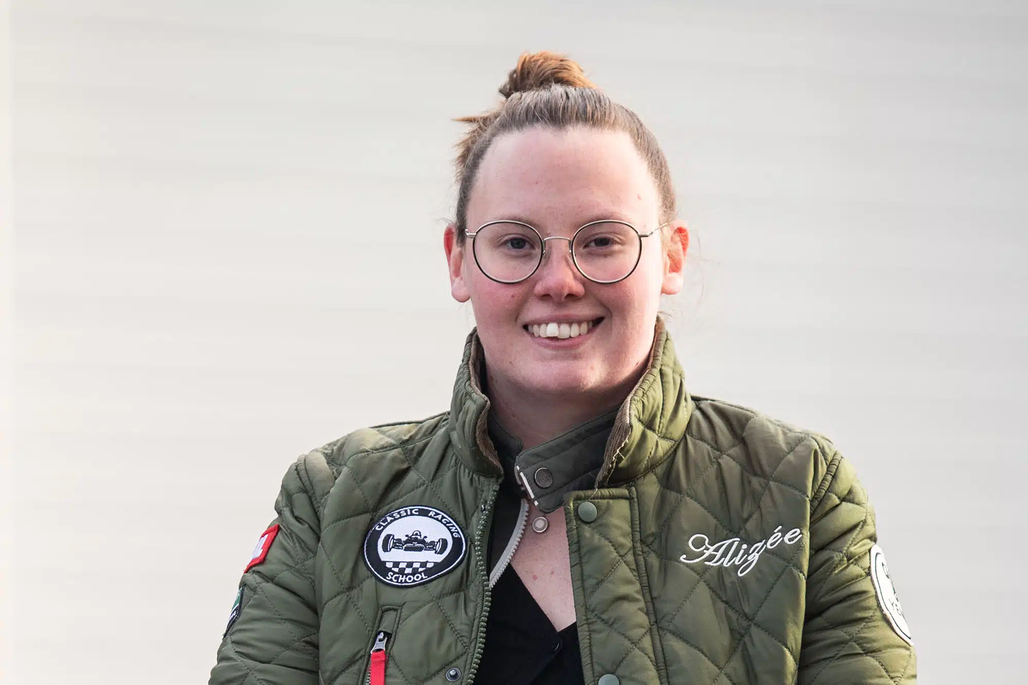 une femme portant des lunettes et une veste verte. L'équipe