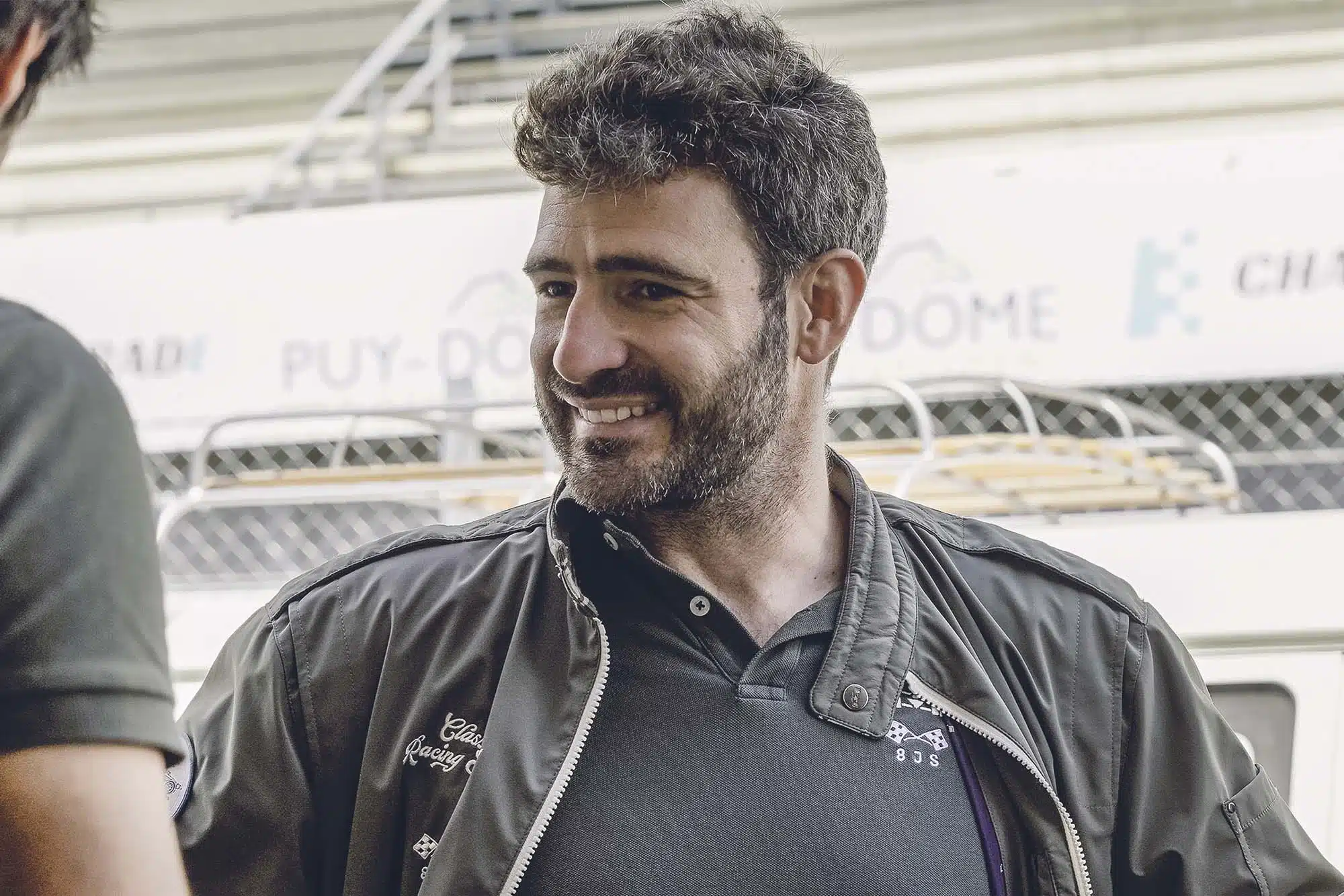 un homme souriant à la caméra. L'équipe